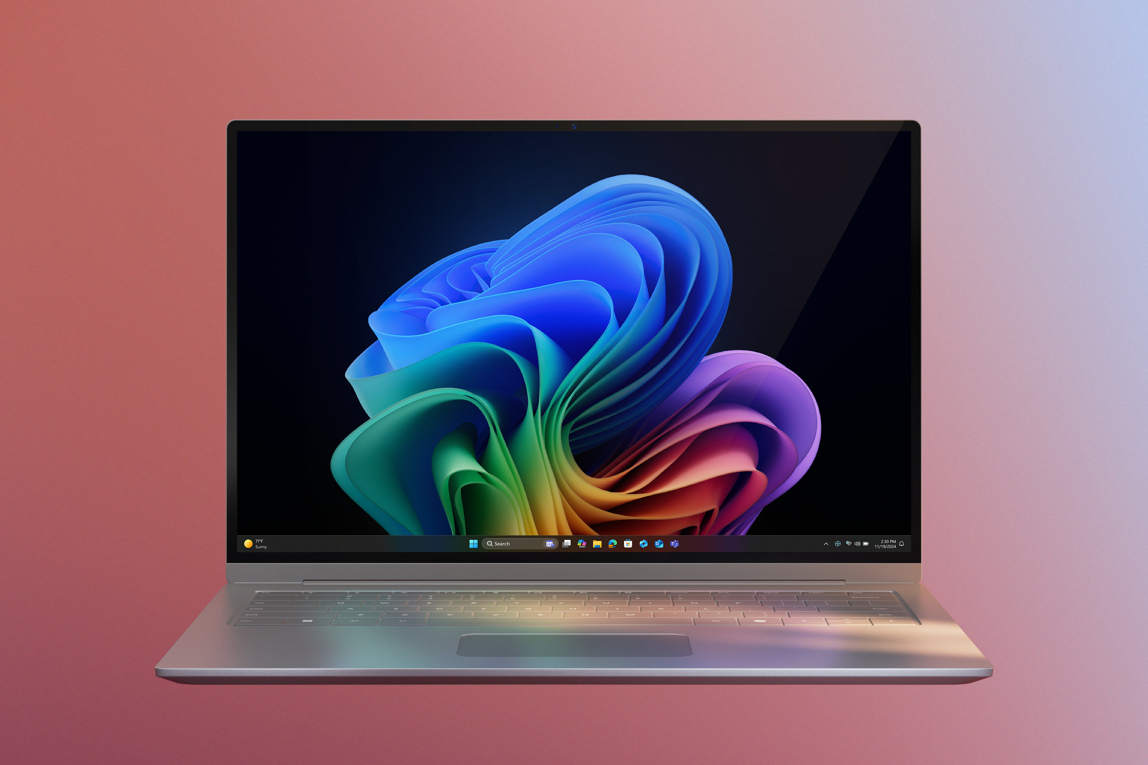 An open platinum laptop with a Windows 11 Pro Copilot+ PC displaying the rainbow bloom image against a gradient pink background
